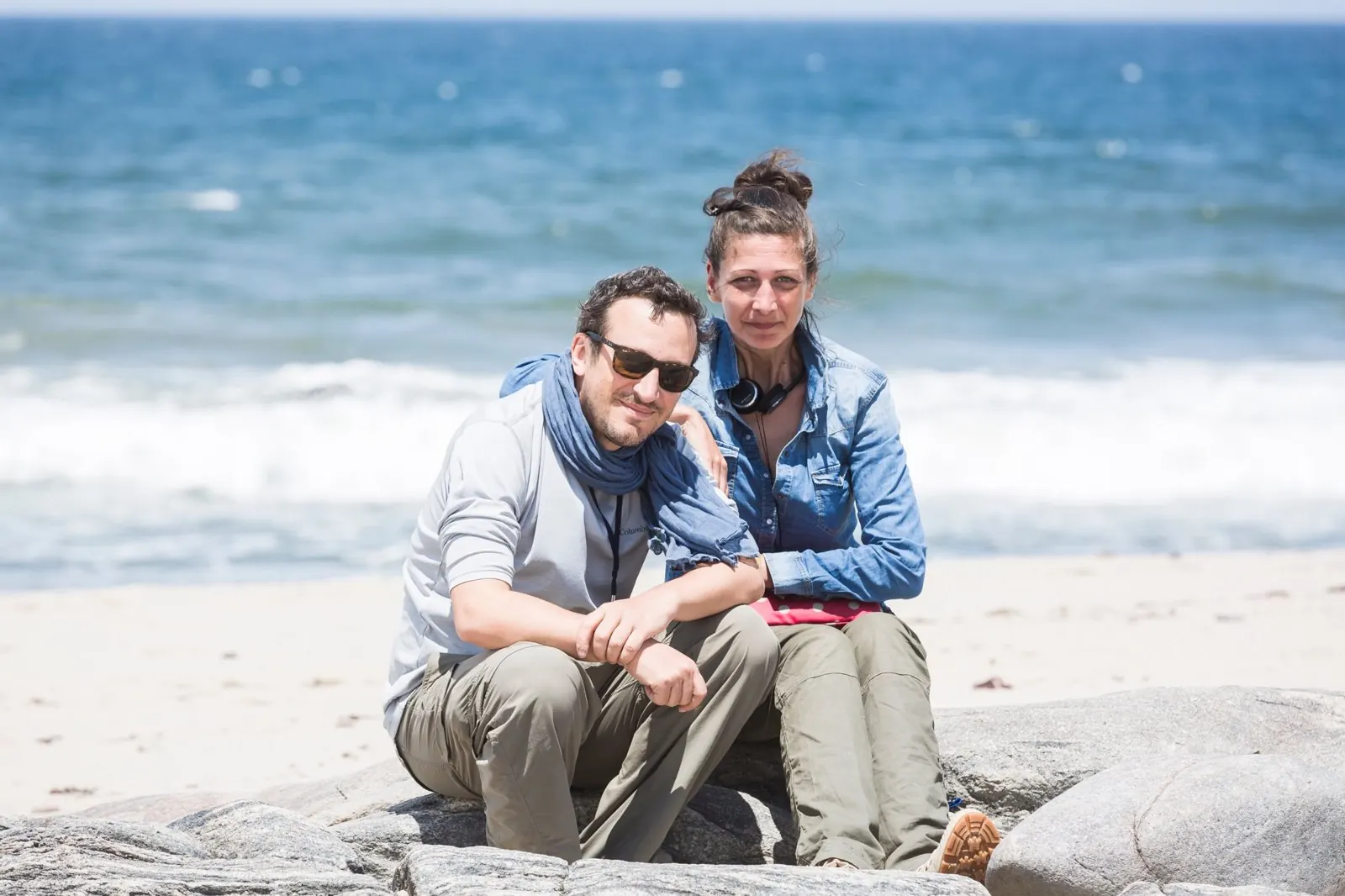Jérémy Henriet et Ombline Rousseau en tournage, assis sur des rochers au bord de l'océan